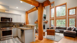 A modern kitchen with granite countertops, stainless steel appliances, and wooden beams. - 3BR | Taluswood | Ski-in/Ski-out | Private Hot Tub | Wood Burning Fireplace | Parking (Whistler)