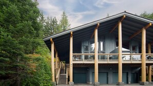 A two-story building with a balcony, large windows, and a staircase leading to the upper level. - 3BR | Taluswood | Ski-in/Ski-out | Private Hot Tub | Wood Burning Fireplace | Parking (Whistler)