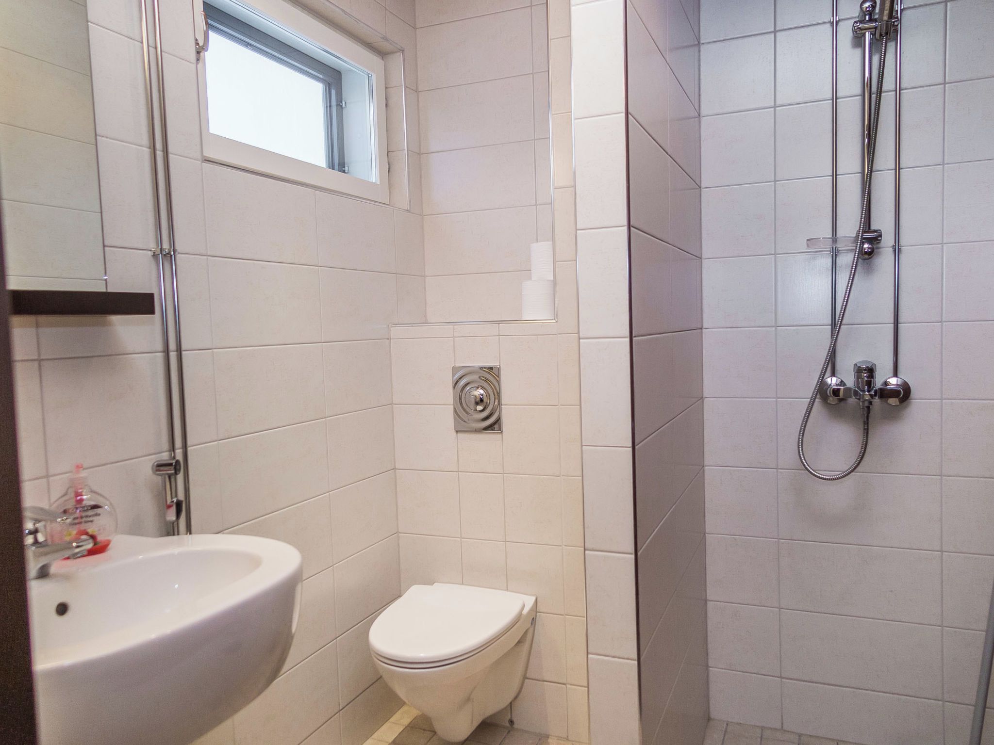 Une salle de bain avec des toilettes, un lavabo et une douche.