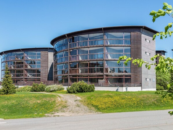 Un bâtiment moderne doté d’une façade incurvée en verre et d’une structure extérieure en briques.