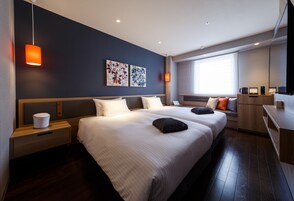 Una habitación de hotel moderna con dos camas, un escritorio y una zona de estar.