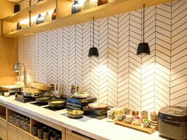 Una cocina moderna con un revestimiento tipo espiga, electrodomésticos de acero inoxidable y una variedad de cuencos y platos sobre la encimera.
