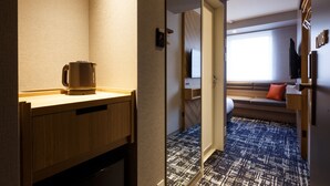 A hotel room with a kitchenette, a sofa bed, a television, and a patterned carpet. - Hotel Forza Osaka Kitahama (Osaka)