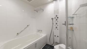 A modern bathroom with a bathtub, a shower, and a toilet.