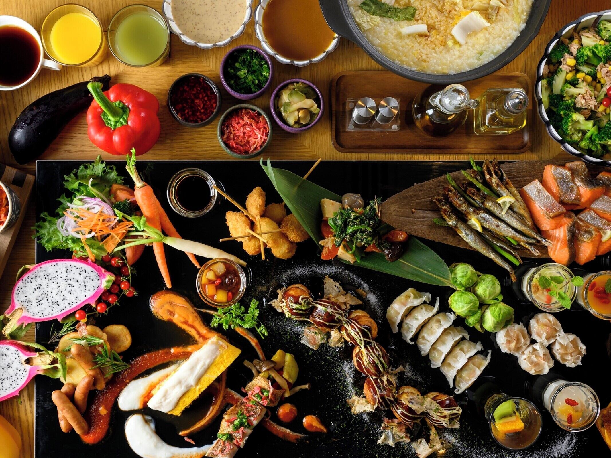 A variety of dishes including sushi, sashimi, and vegetables, suggesting a Japanese cuisine setting.