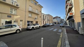 A street with multi-story buildings, parked cars, and a clear sky. - Bleu Bassin by Interhome (Arcachon)