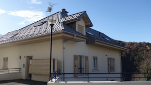 A building with a sloped roof, a security gate, and a clear sky.
