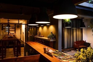 Una cocina moderna con una encimera de madera larga, iluminación colgante y un comedor con bancos.