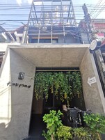 Entrada de un edificio con un letrero que dice "Parking" y un letrero que indica "El cielo viviendo en Chiang Mai".
