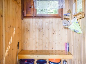 A wooden cabin interior with a window, a shelf with items, and a wooden bench. - Aurinkolahti by Interhome (Viitasaari)