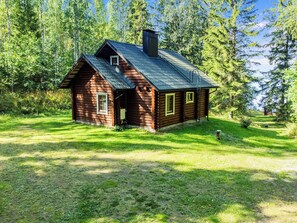 A small log cabin with a sloped roof, surrounded by a grassy area and dense trees. - Aurinkolahti by Interhome (Viitasaari)