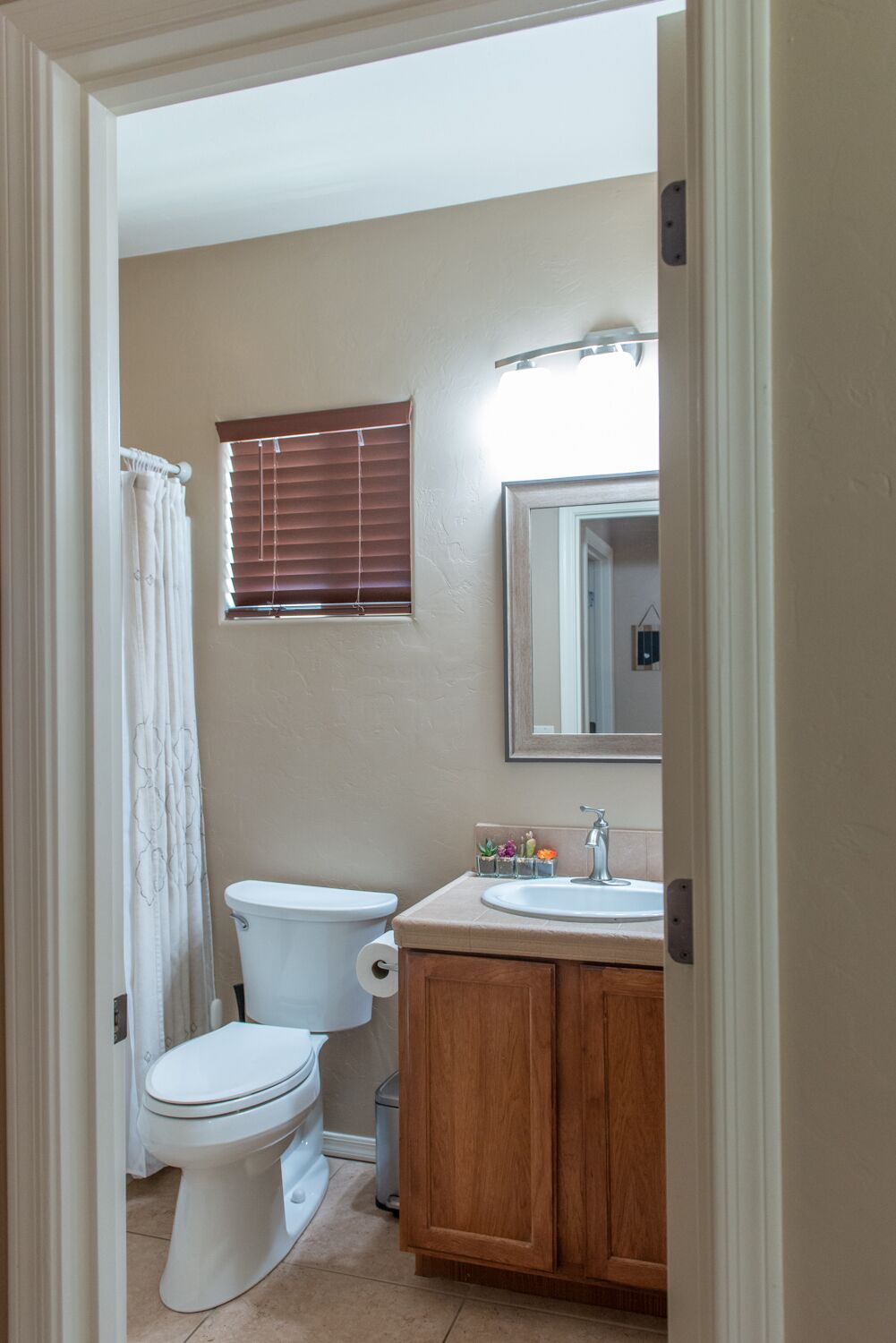 A bathroom with a toilet, a sink, and a mirror.