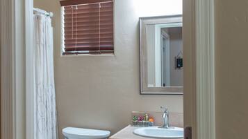 A bathroom with a toilet, a sink, and a mirror.