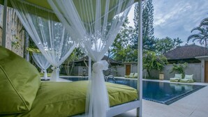 A private pool area with a bed and a canopy. - Villa 3# 1 BR Balinese Villa with public pool (Ubud)