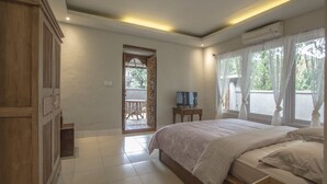 A bedroom with a bed, a TV, and a window with curtains. - Villa 3# 1 BR Balinese Villa with public pool (Ubud)
