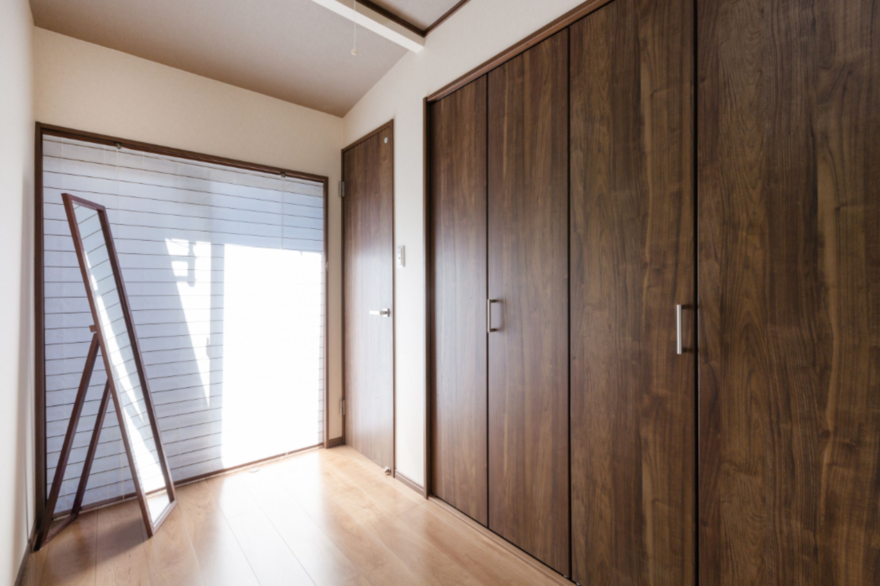 Une pièce dotée d’une grande porte coulissante, d’un plancher en bois et d’une armoire en bois.