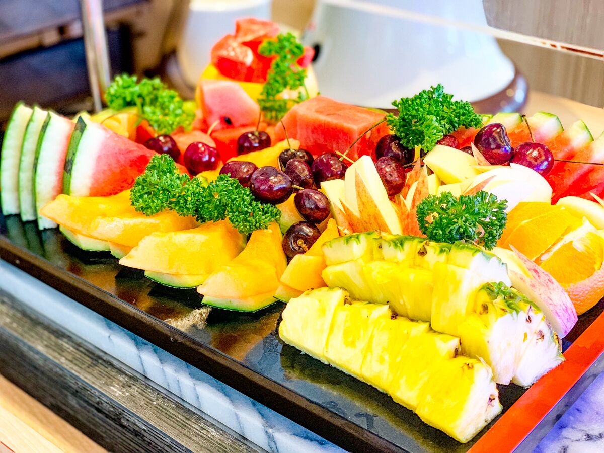 A fruit platter with various fruits and garnishes.