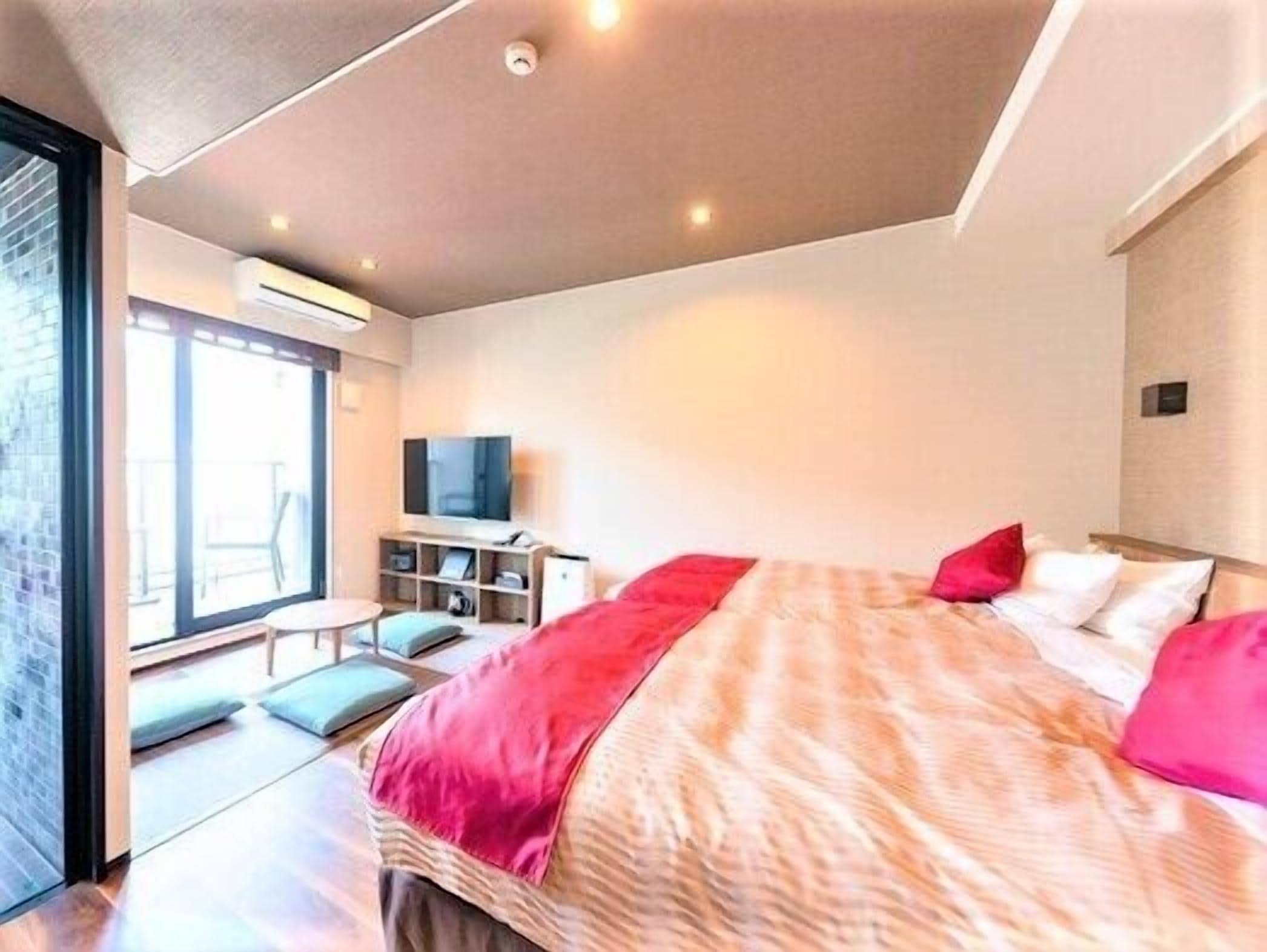 A modern hotel room with a large bed, a television, and a seating area with a view.