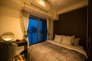 A hotel room with a large bed, a desk with a chair, a desk lamp, and a window with curtains. - Grandouce Tamatsukuri (Osaka)