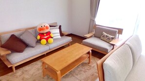 A living room with a sofa, a wooden coffee table, and a plush toy. - Wakayama House No.7 (Wakayama)