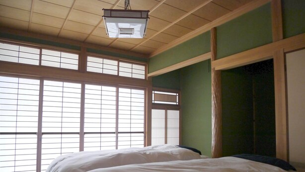 A traditional Japanese-style room with tatami flooring, a low ceiling, and sliding doors. - Wakayama House No.10 (Wakayama)