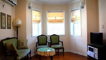 Habitación (12 PY) | Sala de estar | Una televisión de pantalla plana