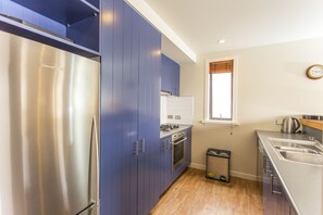 Appartement | Privékeuken | Een koelkast met diepvriezer, een microgolfoven, een oven, een kookplaat