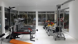 A gym with treadmills, stationary bikes, and weight machines. - Indico Apart Hotel (Nacala)