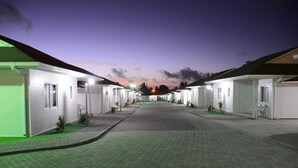 A row of white buildings with a paved walkway in between, likely a hotel or motel. - Indico Apart Hotel (Nacala)