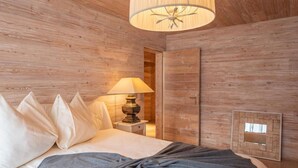 Una habitación con paneles de madera, una cama, una lámpara y un espejo.