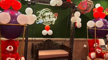 Une pièce avec un fauteuil suspendu, une pancarte « Joyeux anniversaire » et des ballons.