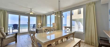 Enjoy meals in this dining area with a large table and ocean views from the windows and balcony.
