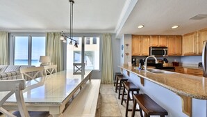 Une cuisine moderne dotée d’un grand îlot central, de meubles en bois et offrant une vue sur l’extérieur.