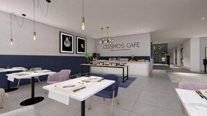 A modern cafe interior with tables, chairs, and a counter displaying food items.