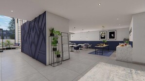 A modern hotel lobby with a geometric wall design, seating areas, and a reception desk.