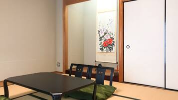 Une pièce de style japonais traditionnel, avec un sol recouvert de tatamis, une table basse et une porte coulissante.