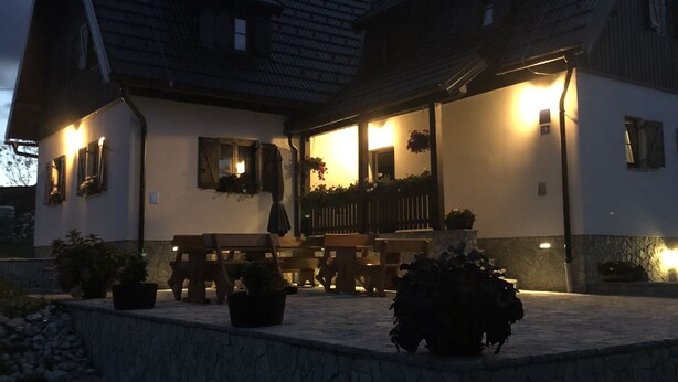 Ein großes, zweistöckiges Haus mit geneigtem Dach und einer überdachten Terrasse.