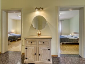 Una habitación de hotel con un aparador de madera, un espejo y dos camas.