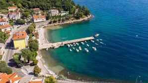 An aerial view of a coastal town with a marina, buildings, and a clear blue sea. - Apartment Franjo by Interhome (Opatija/Ika)