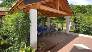 A covered patio with a table and chairs, surrounded by greenery. - Apartment Franjo by Interhome (Opatija/Ika)