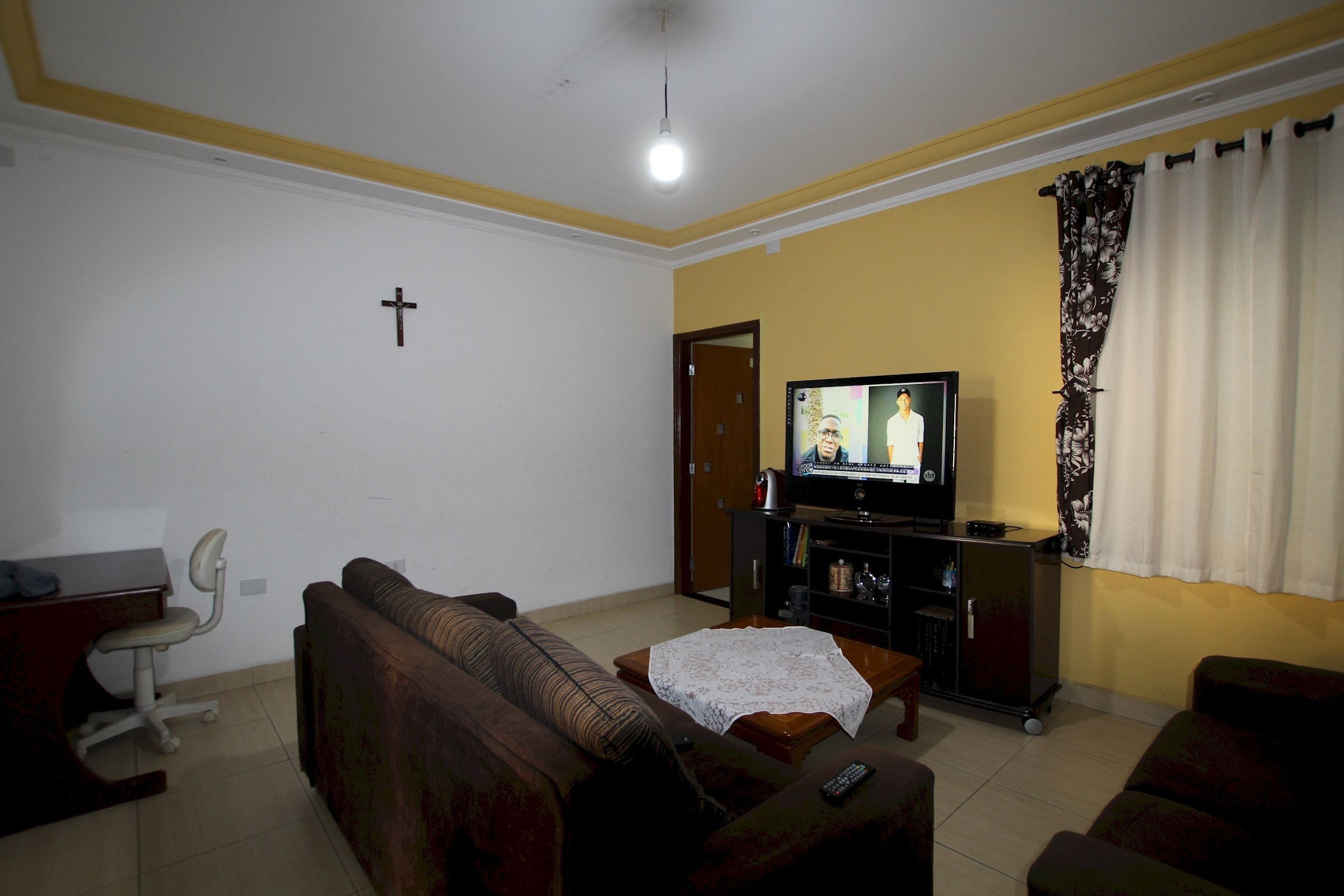 Una sala de estar con sofá, televisión y una mesita.