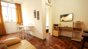 A room with a bed, a desk, a chair, and a television. - Gohouse - Baependi 503 (Rio de Janeiro)