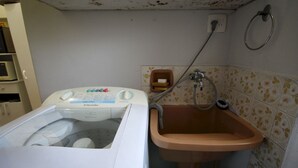 A washing machine and a sink in a small bathroom with floral tiles. - Gohouse - Botafogo 419 (Rio de Janeiro)