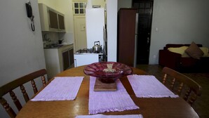 A dining table with placemats, a glass bowl centerpiece, and wooden chairs. - Gohouse - Botafogo 419 (Rio de Janeiro)