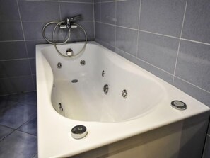 A modern bathroom with a freestanding bathtub, a handheld showerhead, and a built-in faucet. - La Busa by Interhome (Alleghe)