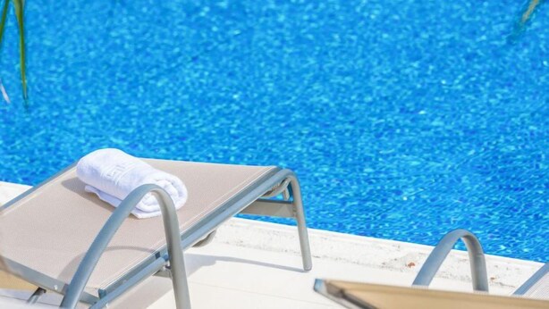 A poolside area with a lounge chair and a towel. - Malu Sun II by Interhome (Brodarica)