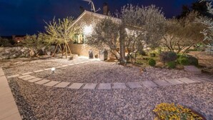 A stone house with a stone pathway leading to the entrance, surrounded by various plants and trees. - Malu Sun II by Interhome (Brodarica)
