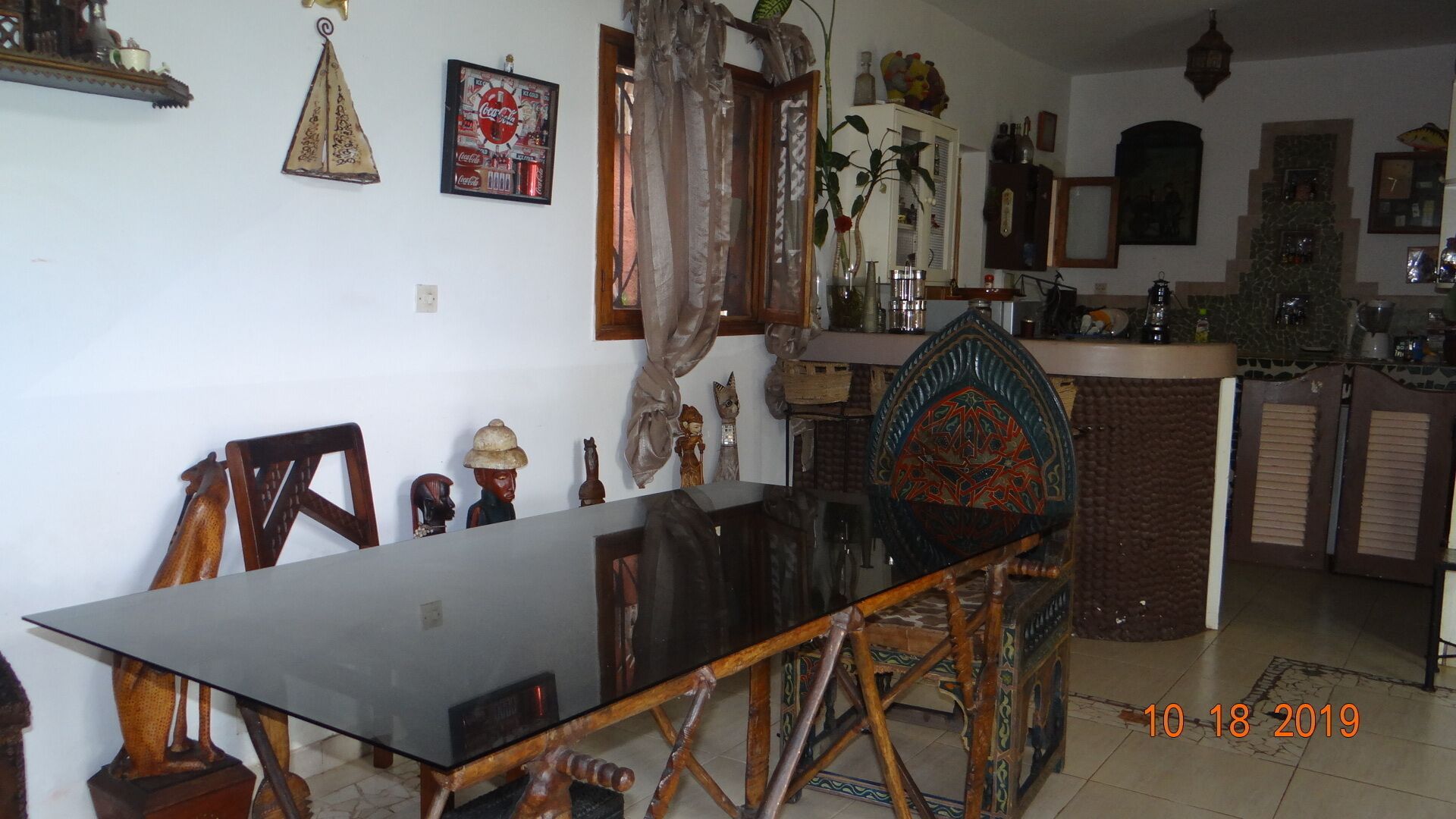Uma área de refeições com uma mesa comprida, cadeiras e um aparador decorativo.