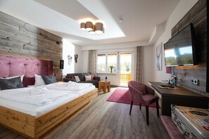 A modern hotel room with a wooden bed, a desk, a chair, a TV, and a balcony with a view of the outdoors. - Landhotel Thälerhäusle Ochsen (Furtwangen)