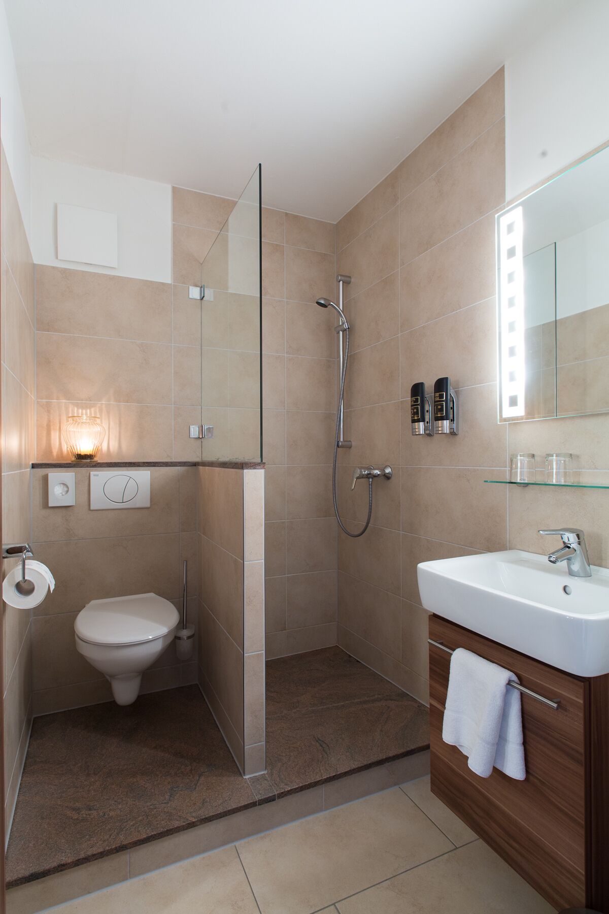 A modern bathroom with a glass shower enclosure, a toilet, and a sink with a vanity.